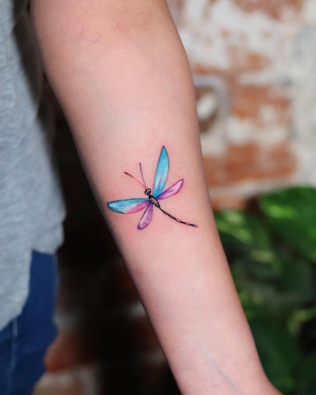 Vibrant dragonfly tattoo on forearm Tattoo Design