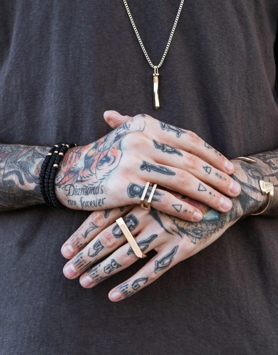 Minimalism meets intricate detail in this striking hand tattoo that blends geometric shapes with fine lines.