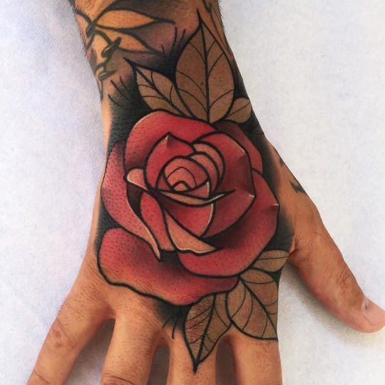 A bold red rose tattoo on the hand is a classic design that never goes out of style.