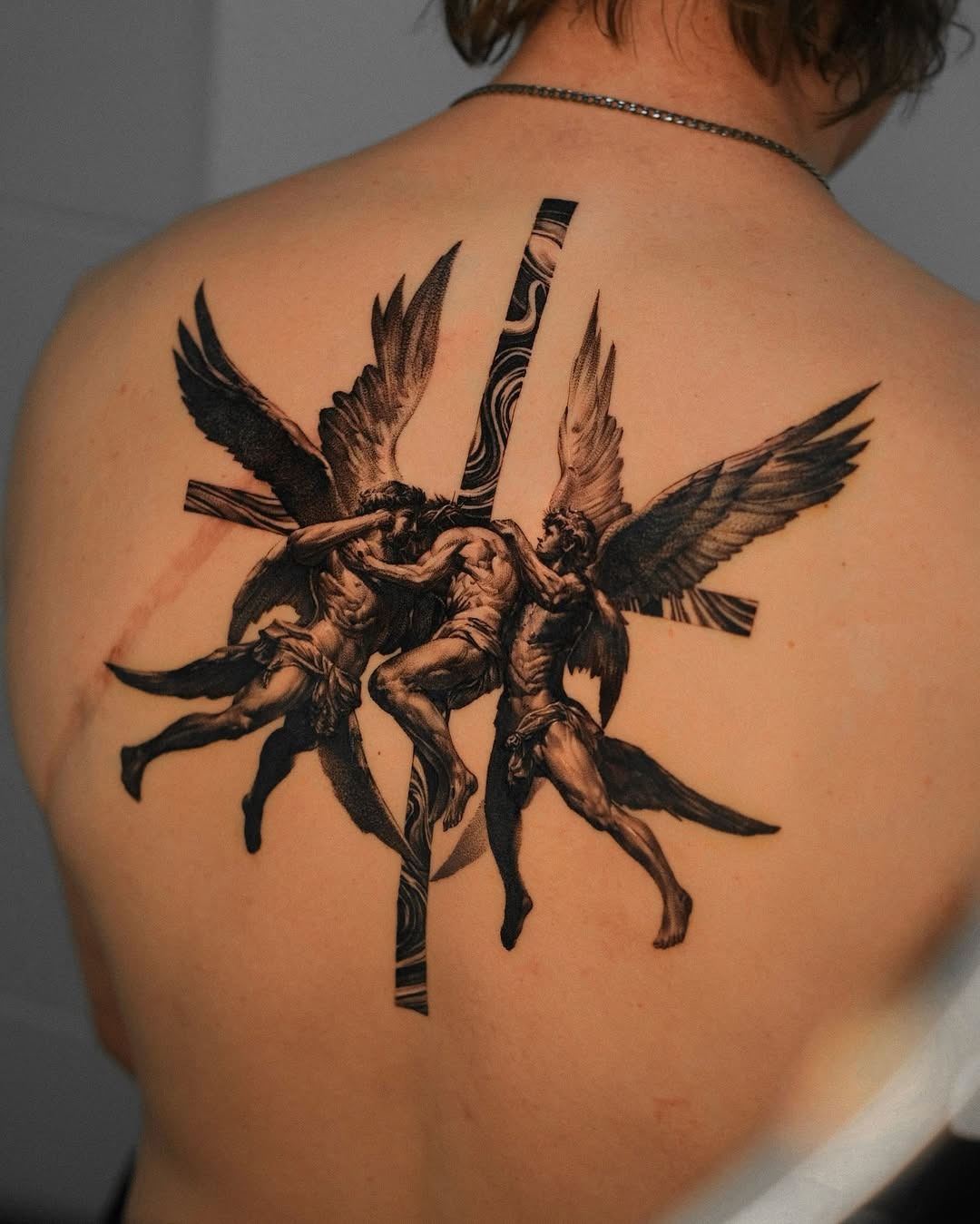 Dramatic angelic wrestling tattoo on the back Tattoo Design