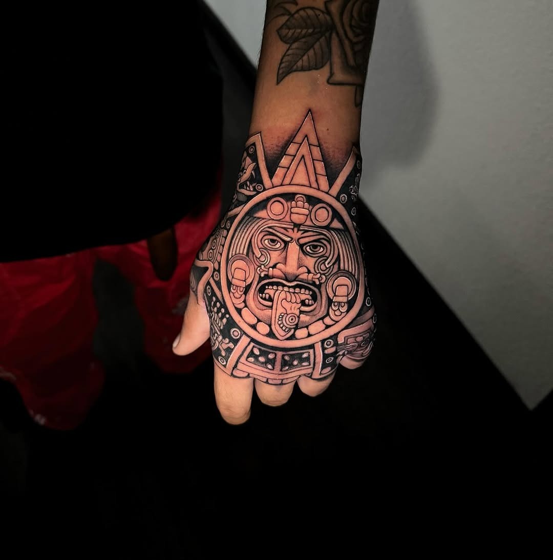 Intricate Aztec god tattoo on hand Tattoo Design