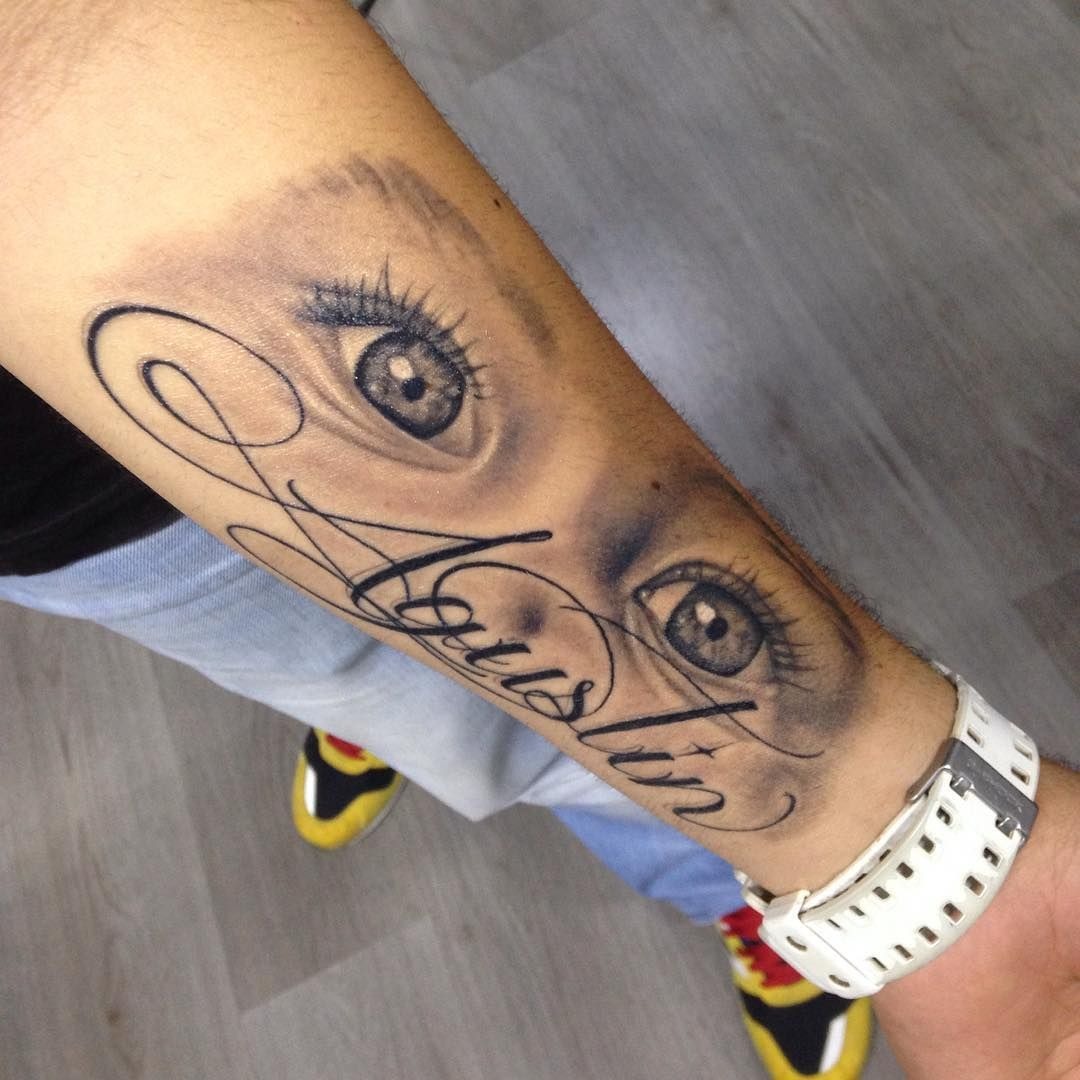 Realistic Baby Eyes Tattoo With Flowing Name Tattoo Design