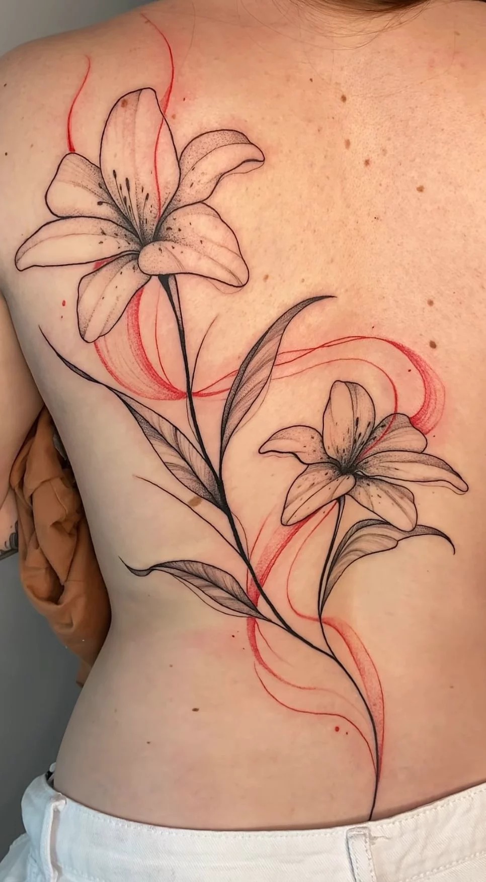 Elegant Lily Back Tattoo With Red Flow Lines Tattoo Design