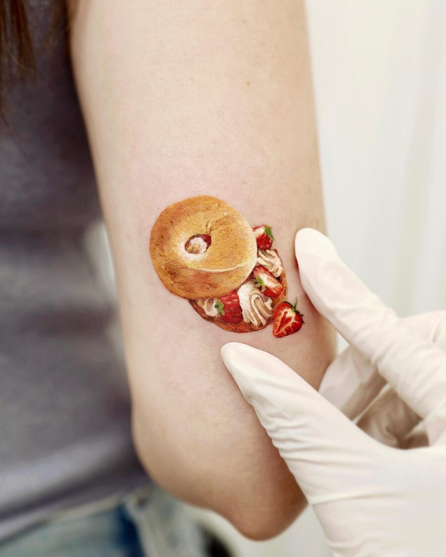Delightful bagel tattoo with strawberry accents Tattoo Design