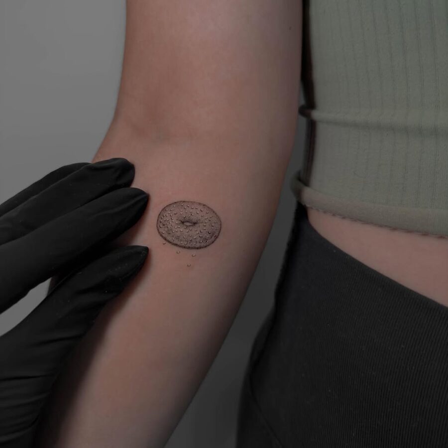 Delightfully realistic bagel tattoo on arm Tattoo Design