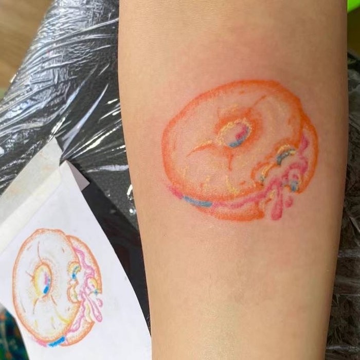 Vibrant bagel tattoo with colorful icing details Tattoo Design