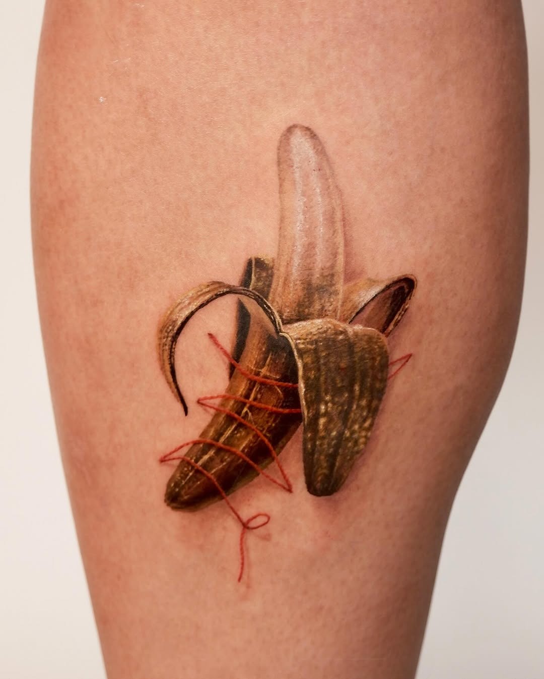 This stunning banana tattoo showcases intricate realism with colors.