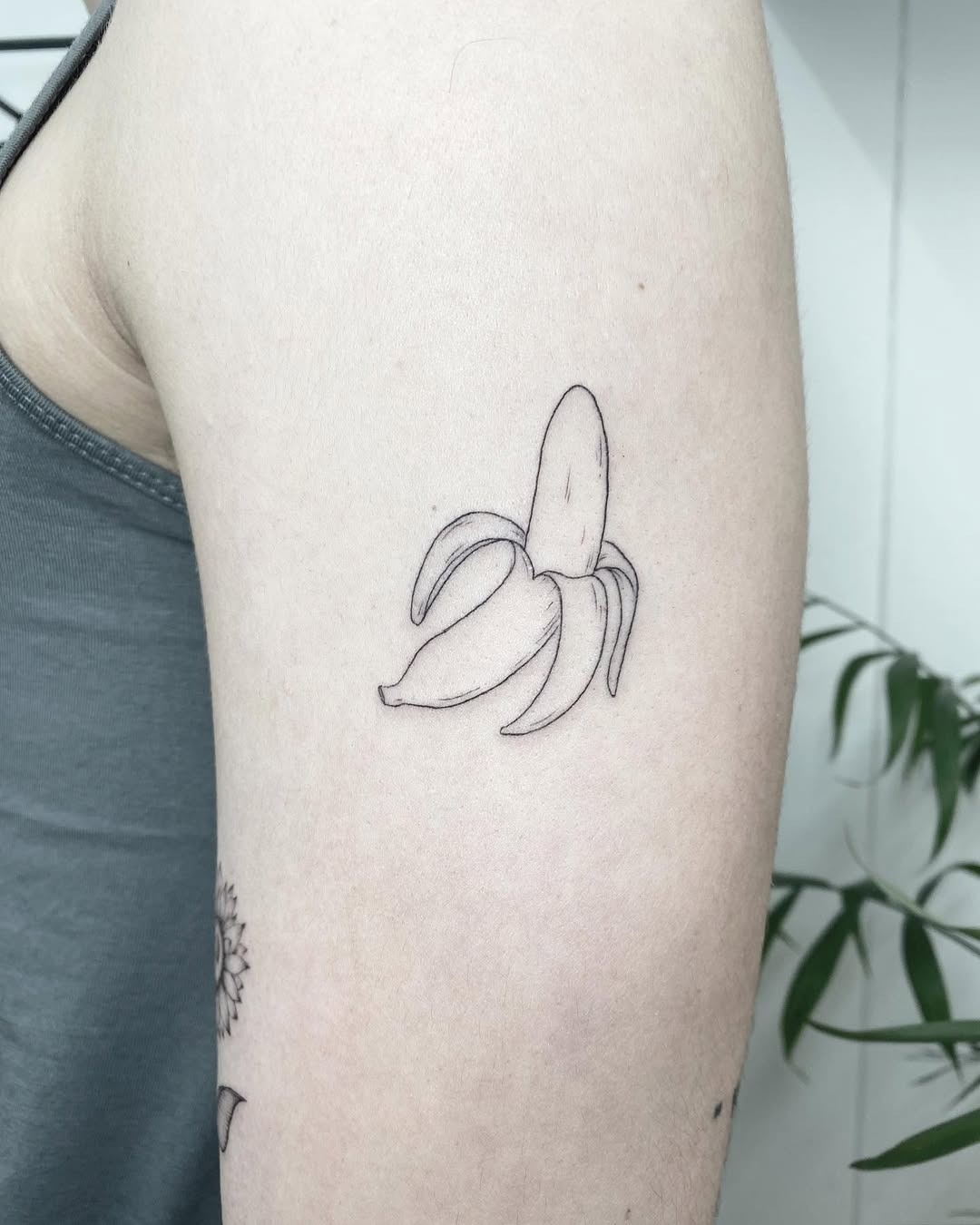 This tattoo captures a simple yet charming banana in fine linework.