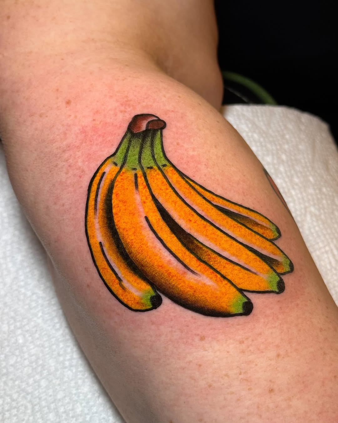 This tattoo features a bunch of bright, playful bananas, showing their cheerful yellow tones and subtle green highlights.