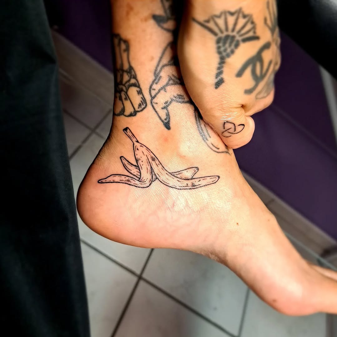 This playful tattoo showcases two banana peels resting on the ankle.