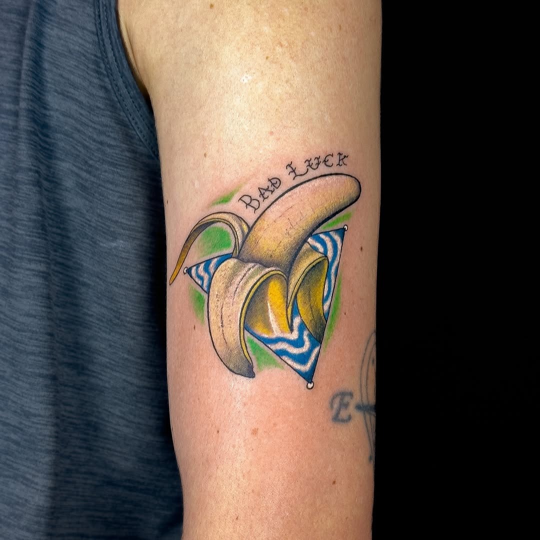 This banana tattoo, nestled in a geometric design, exudes a playful charm.