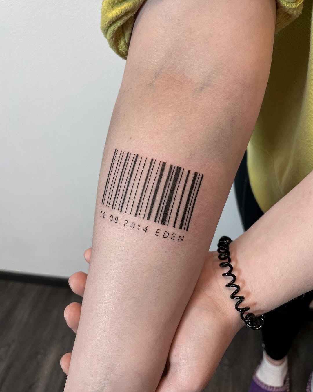 This barcode tattoo creatively blends personal significance with a minimalist design.