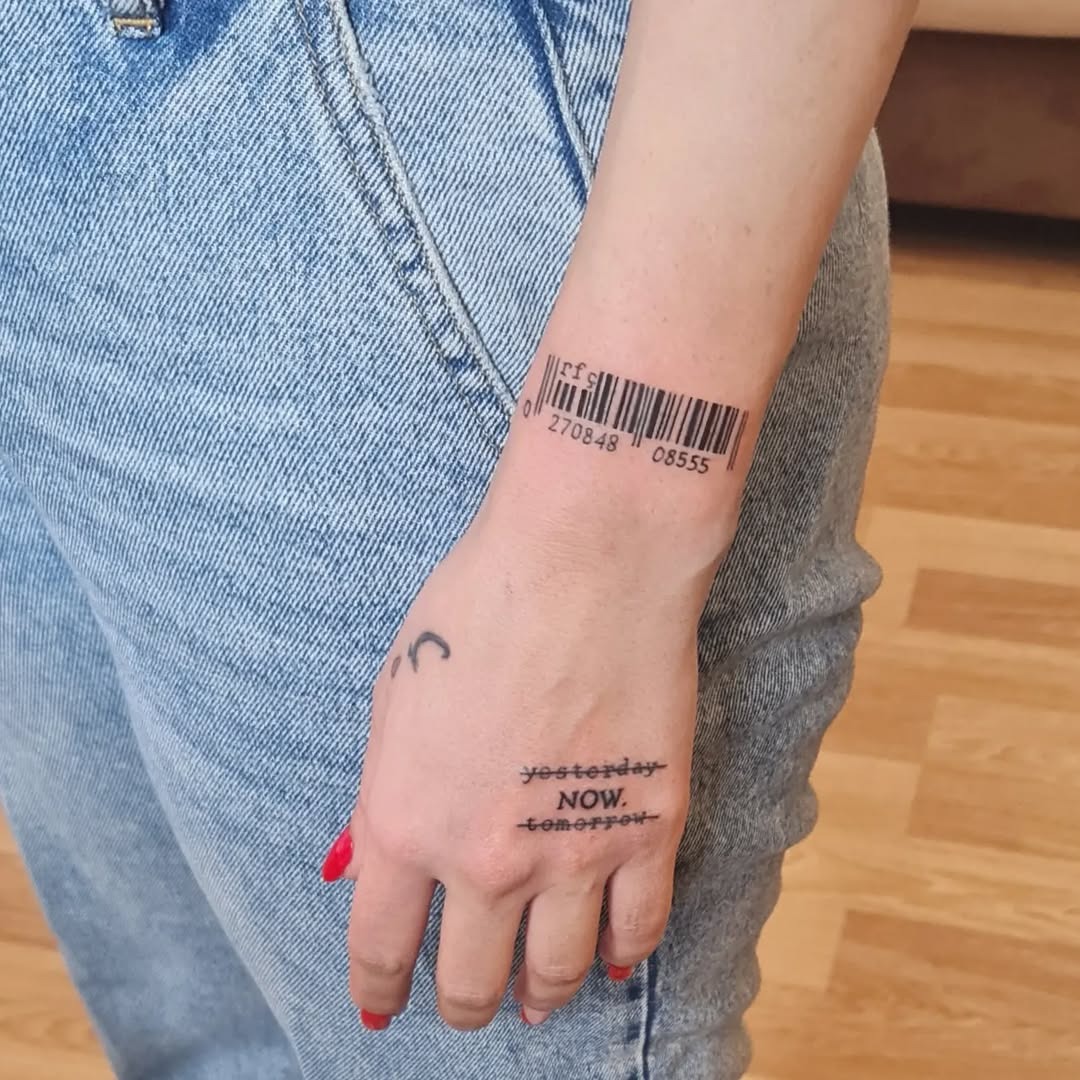 This tattoo features an intricate barcode design on the wrist, blending subtlety with a modern edge.