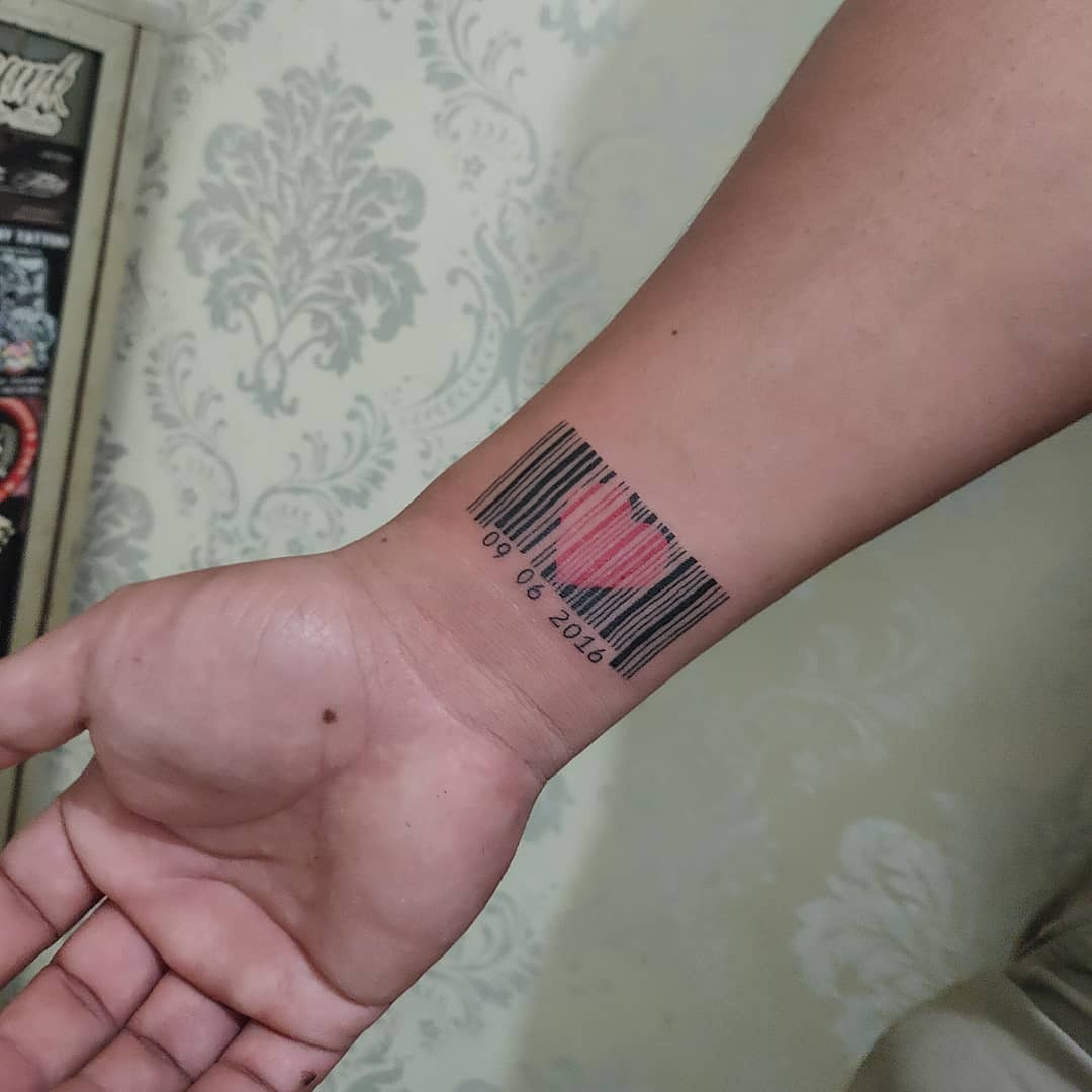 This tattoo showcases a clever design where a traditional barcode forms the shape of a heart.