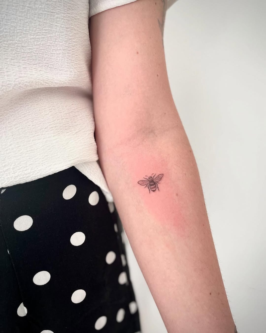 Charming minimalist bee tattoo on the arm Tattoo Design