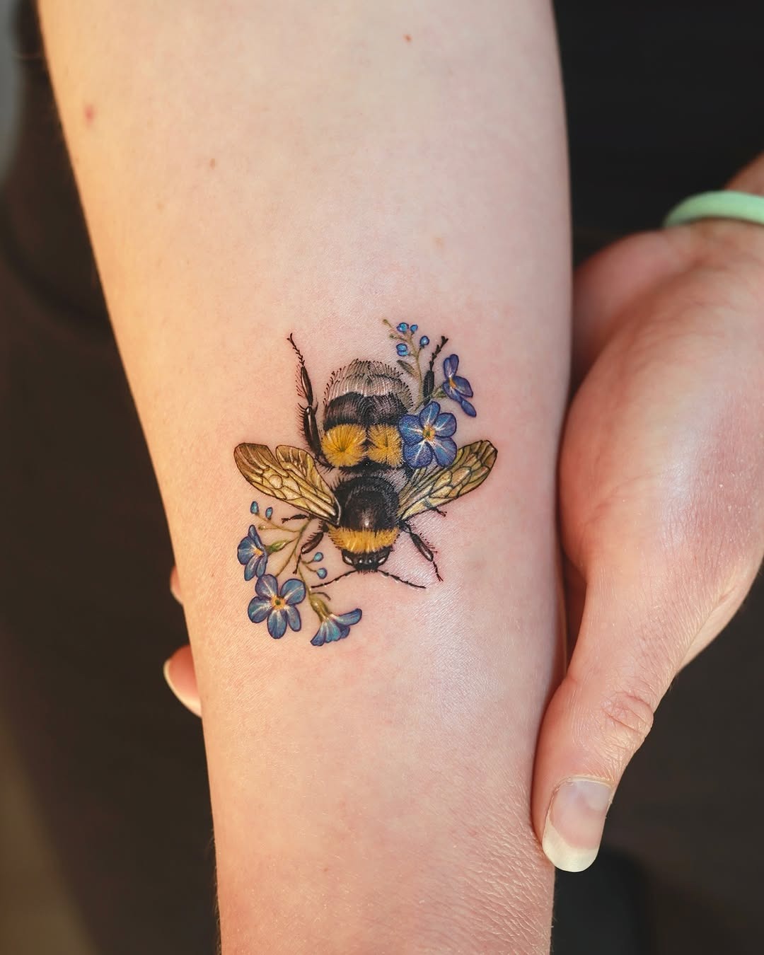 Colorful bumblebee surrounded by delicate flowers Tattoo Design
