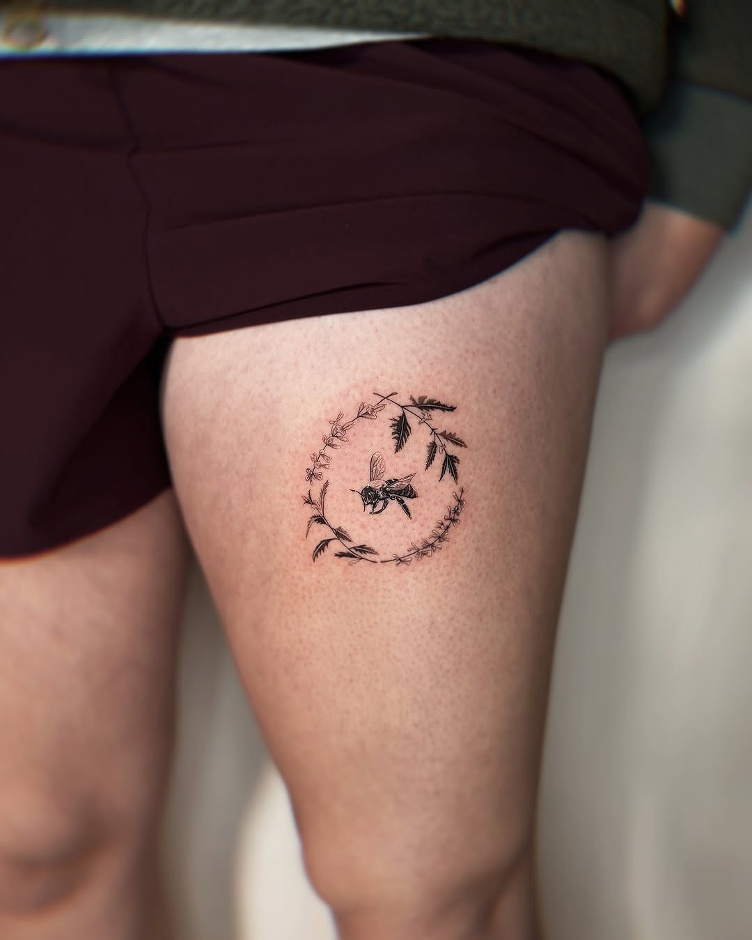 Elegant bee tattoo encircled by delicate flora Tattoo Design
