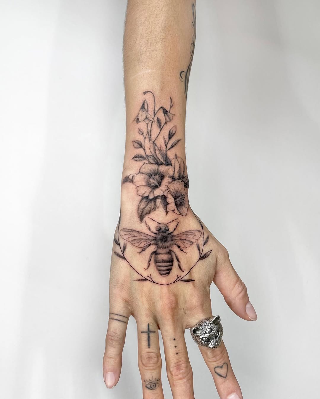 Elegant floral-themed bee tattoo on hand Tattoo Design