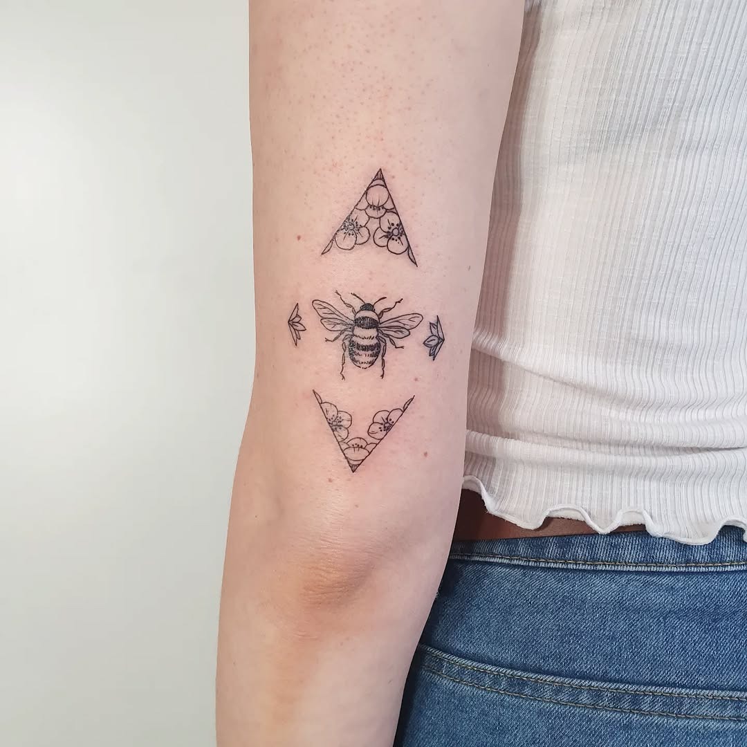 Stylish geometric bee tattoo with floral accents Tattoo Design