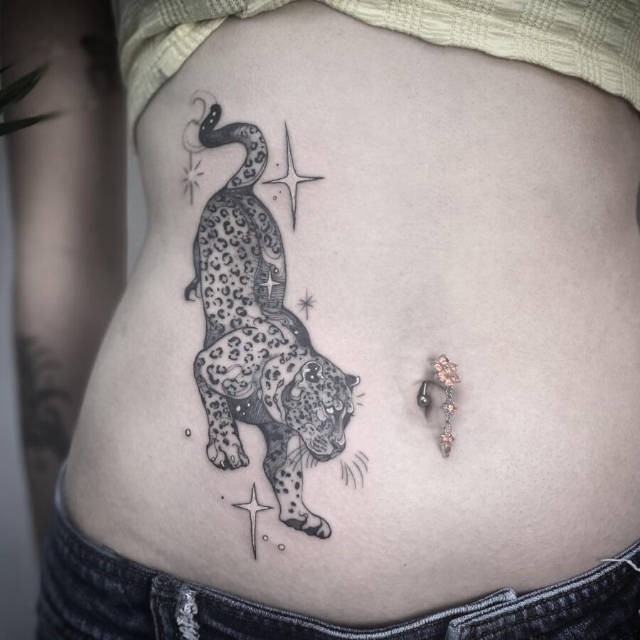 This belly tattoo features a striking leopard in motion, showing intricate details and shading.