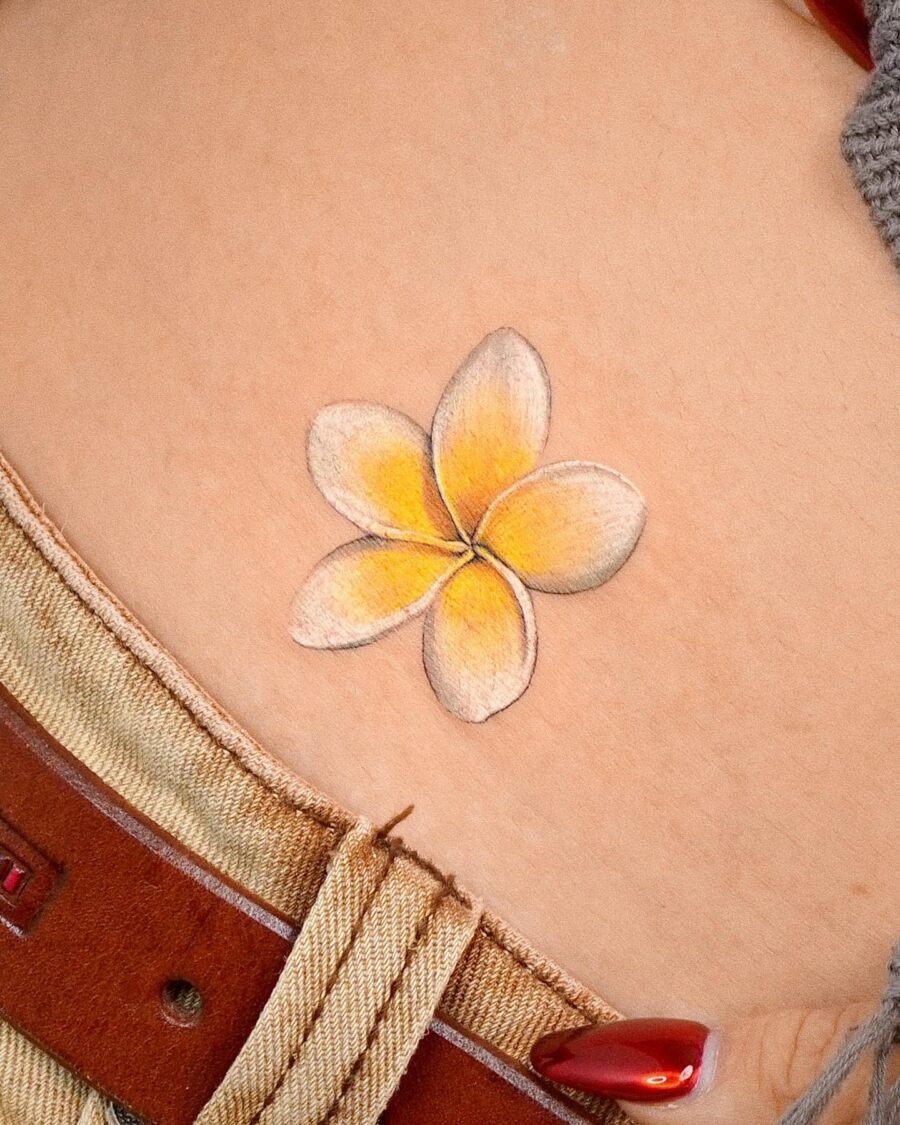 This delicate flower tattoo radiates charm with its soft yellow and white hues.
