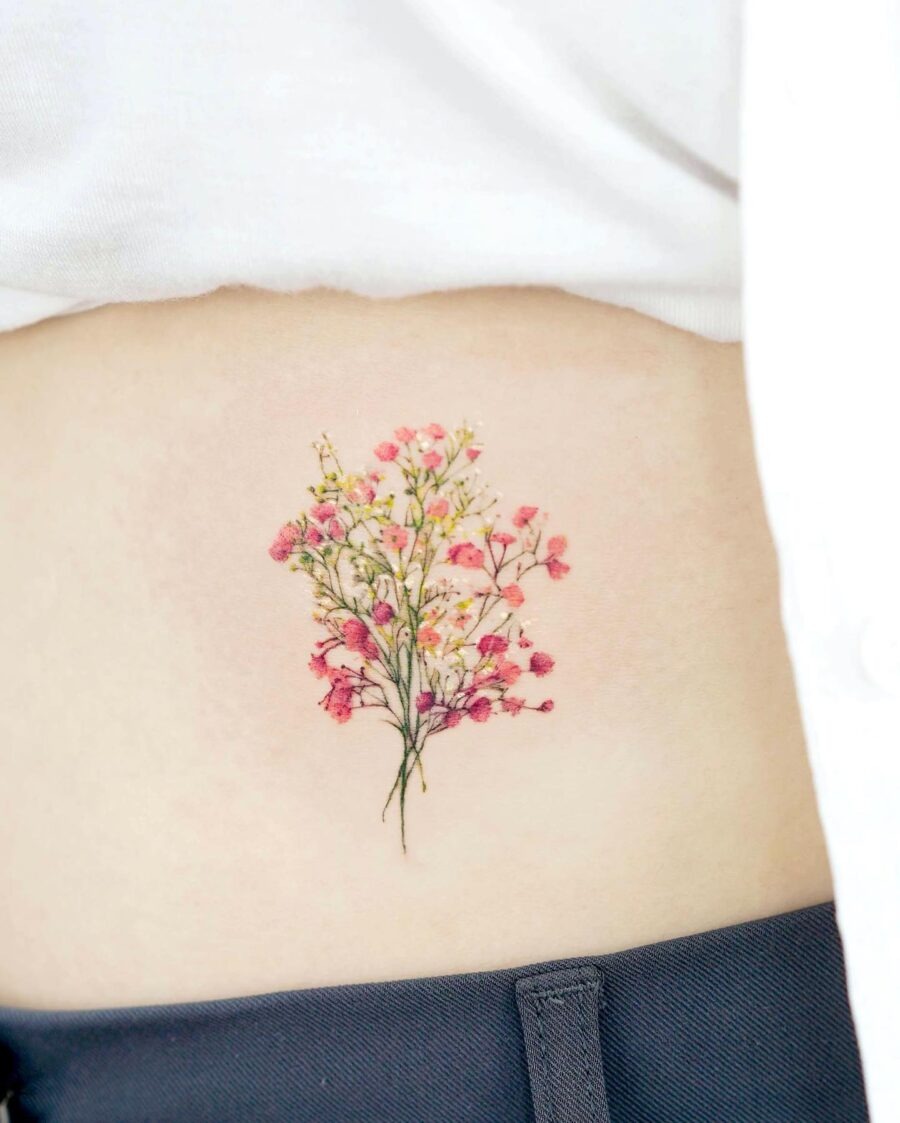 This stunning belly tattoo features a bouquet of delicate pink and white flowers, adding a touch of elegance to the skin.
