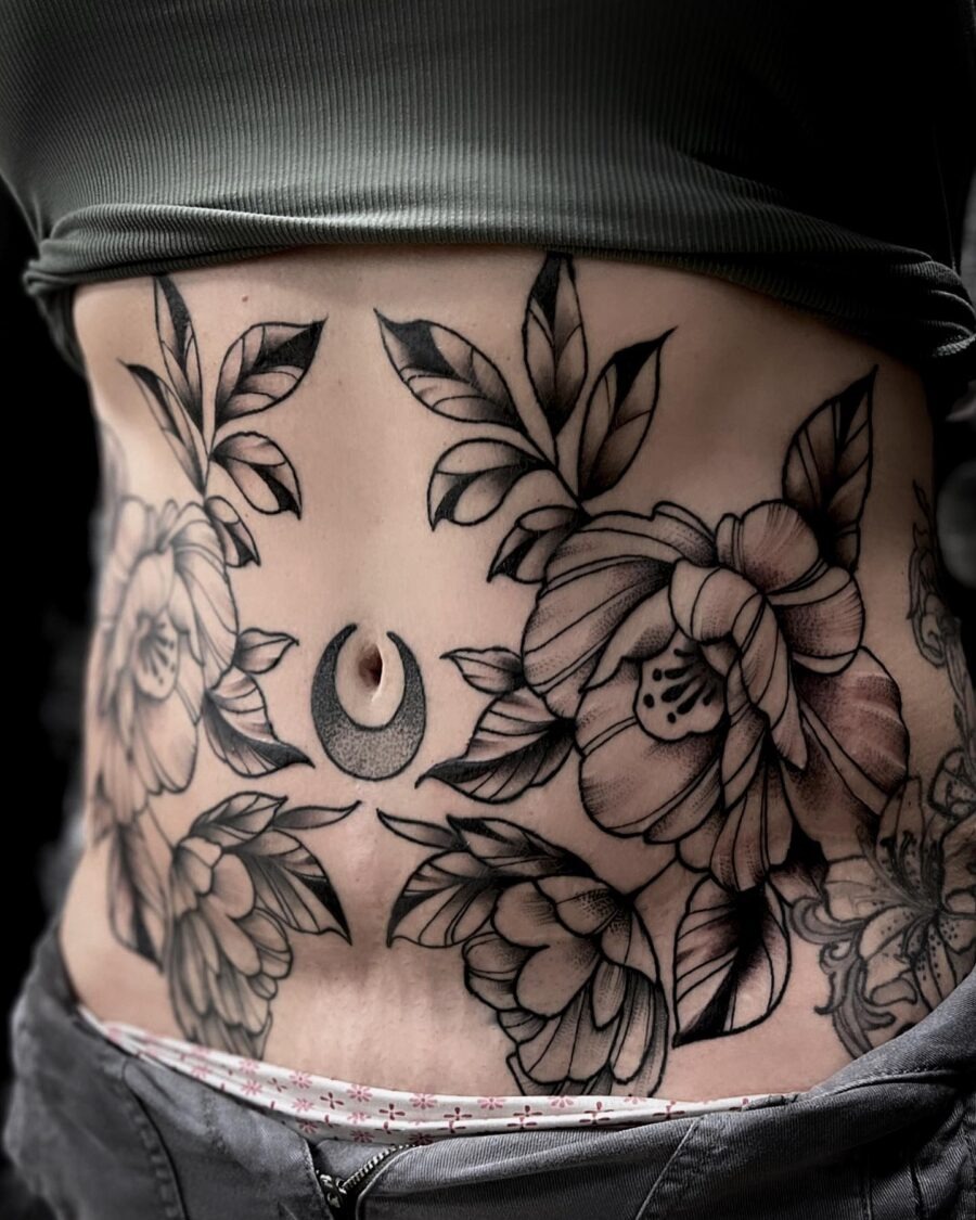 This tattoo features beautifully detailed flowers surrounding a crescent moon, creating a stunning visual impact.