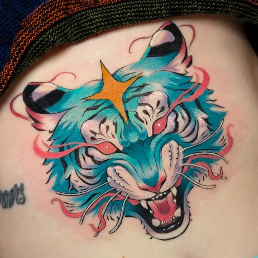 This stunning belly tattoo showcases a fierce tiger face bursting with color.