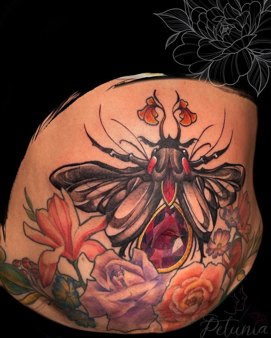 This captivating belly tattoo showcases a large, intricately designed butterfly surrounded by flowers.