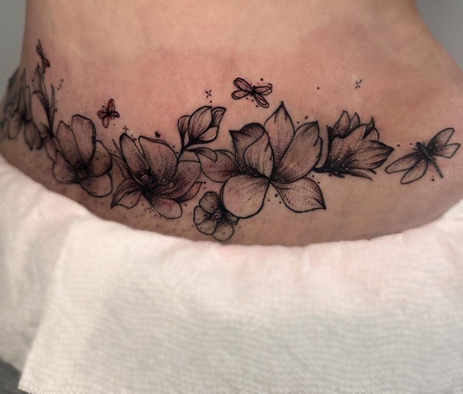 This belly tattoo showcases a harmonious blend of flowers with delicate butterflies.