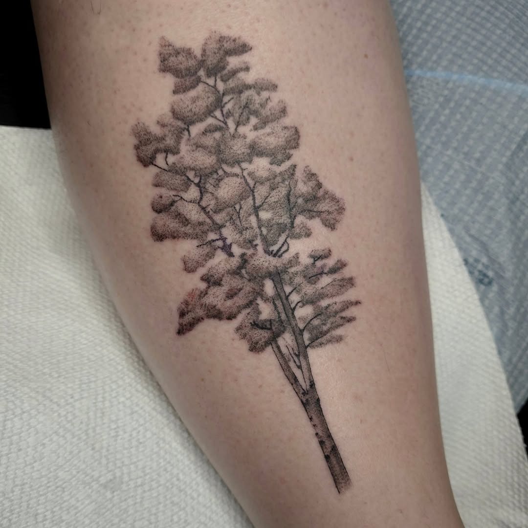 This stunning birch tree tattoo captures the beauty of nature in a delicate design.