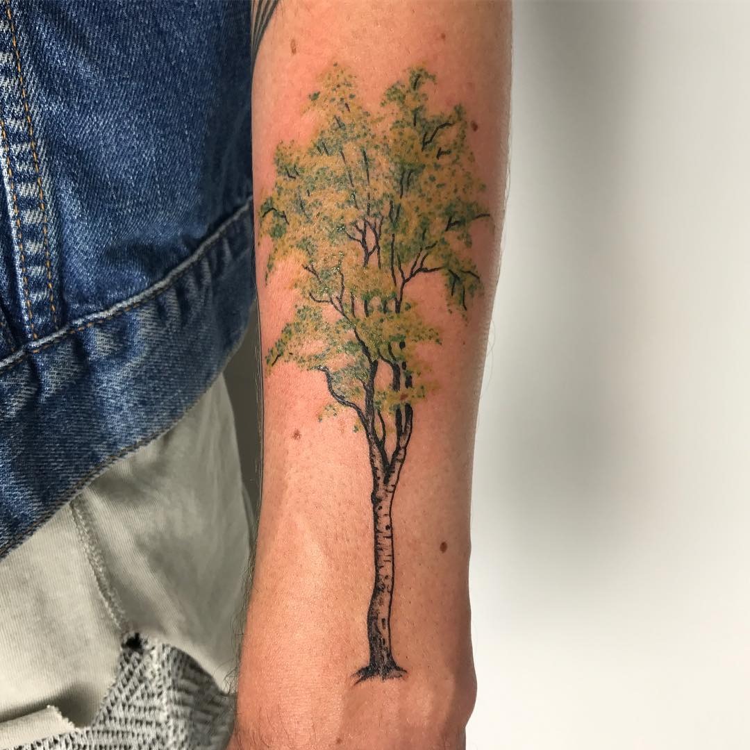This beautiful birch tree tattoo captures nature's essence with its intricate details and colors.
