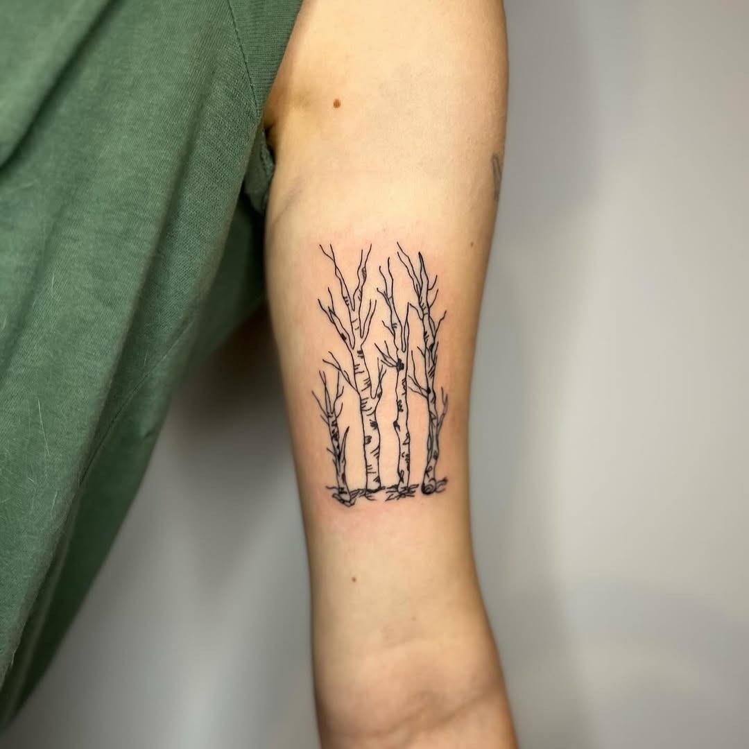 This tattoo features a delicate depiction of birch trees, showing their beautiful bark and slender forms.