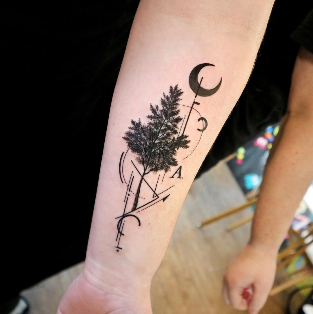 This tattoo features a striking birch tree, intricately designed with geometric lines and moon phases.