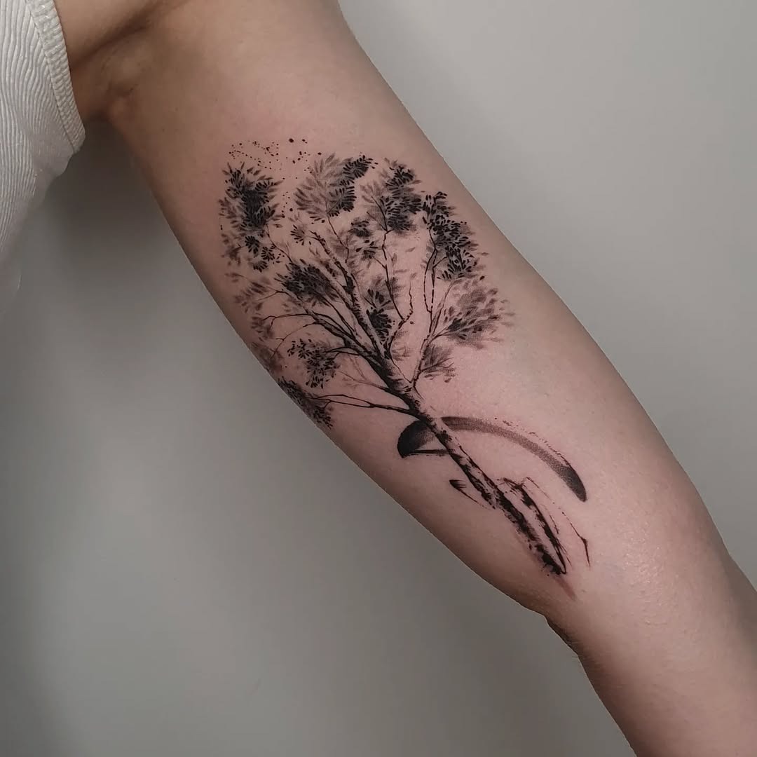 This impressive tattoo features a birch tree intricately illustrated in black ink.