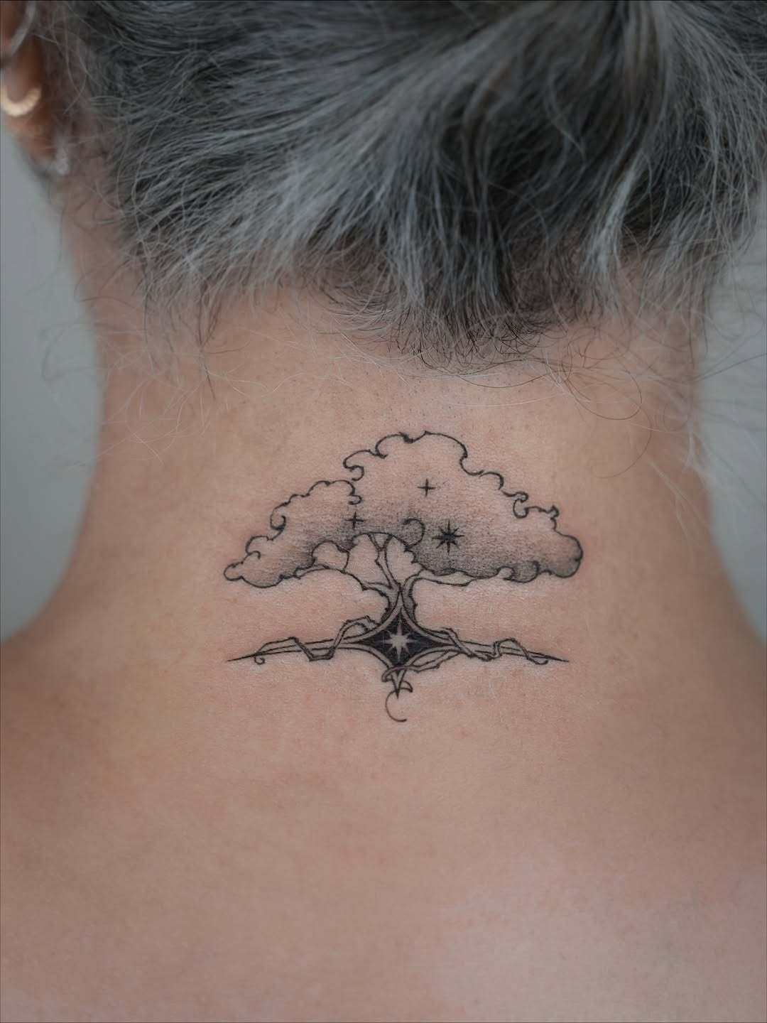 This stunning birch tree tattoo is elegantly etched on the back of the neck.