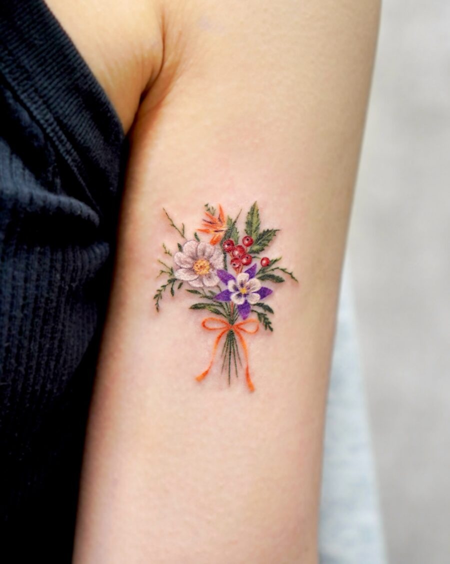 This tattoo features a beautiful bouquet adorned with various flowers, showing intricate colors and lively greenery.