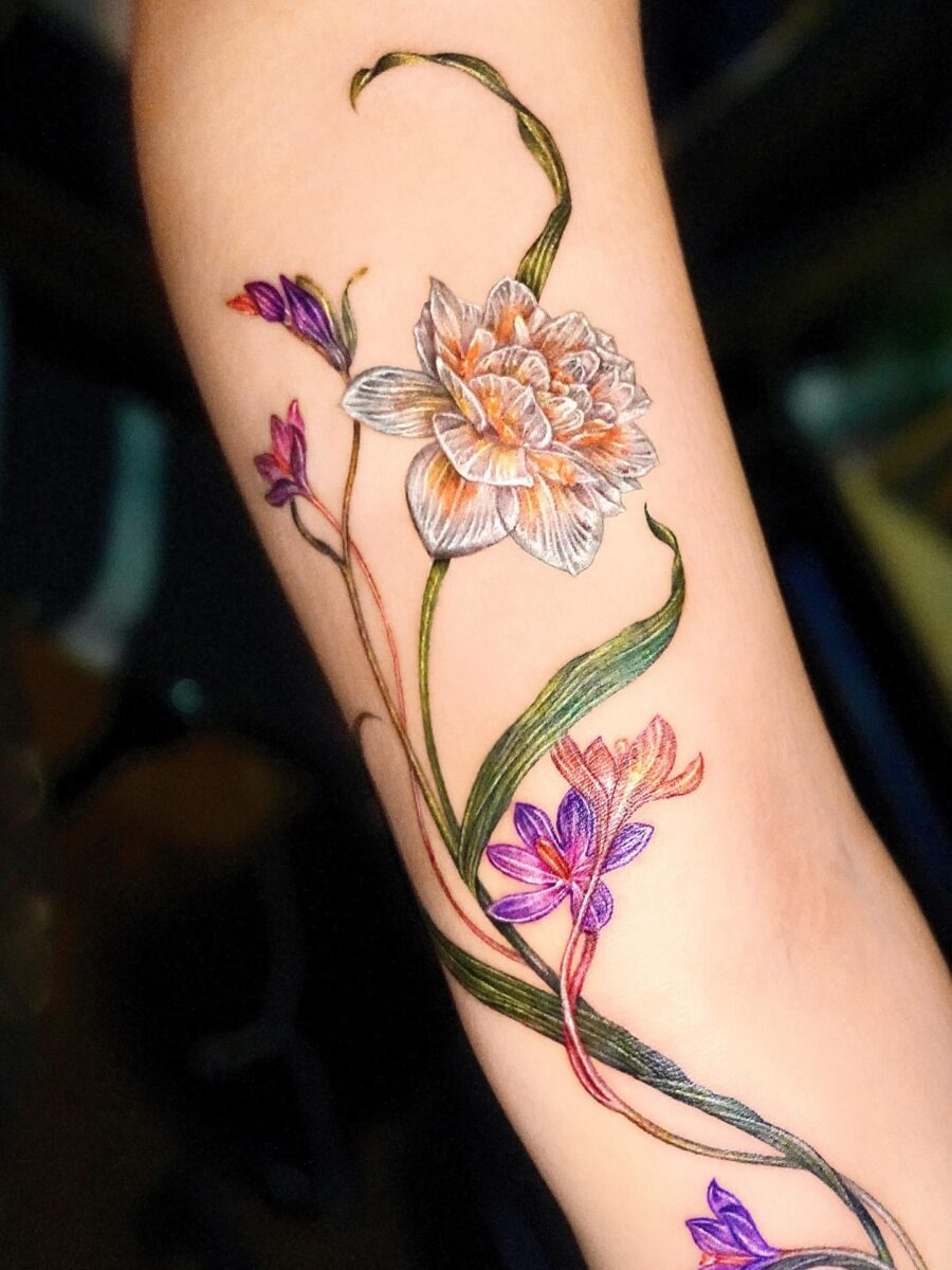 This tattoo features intricate floral designs showing the beauty of birth flowers.