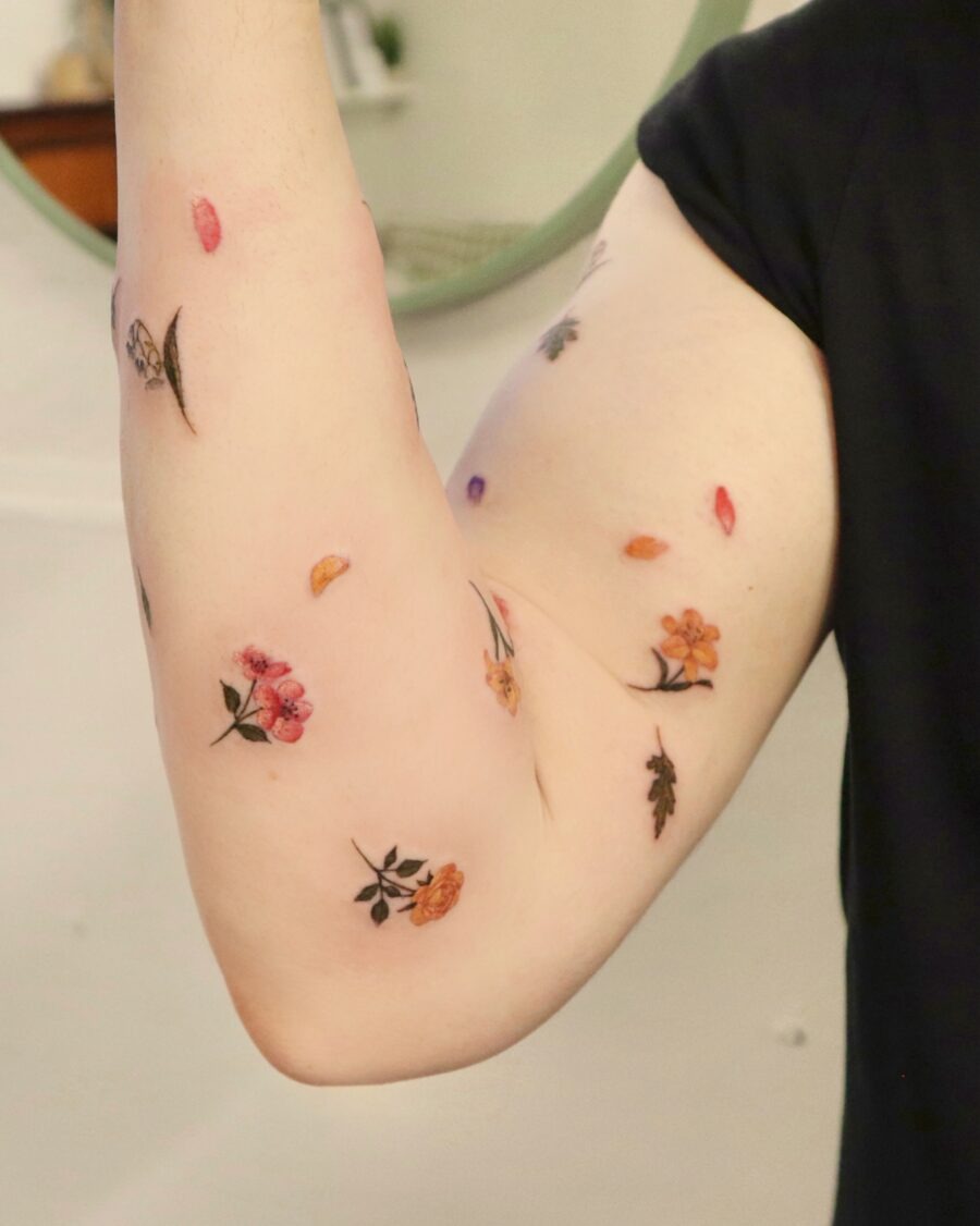 This image showcases a beautiful array of birth flower tattoos adorning the inner arm.
