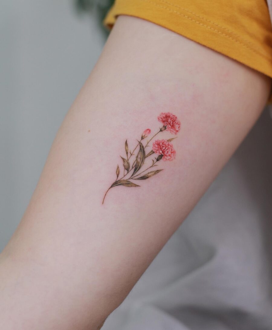 This beautiful arm tattoo features soft pink carnations, symbolizing admiration and love.