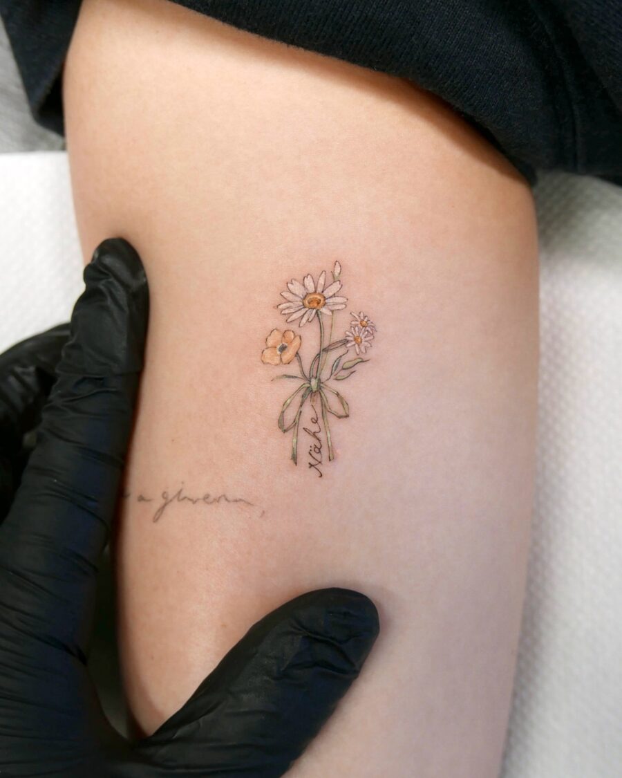 This tattoo showcases a beautiful arrangement of daisy flowers, crafted in a minimalist style.