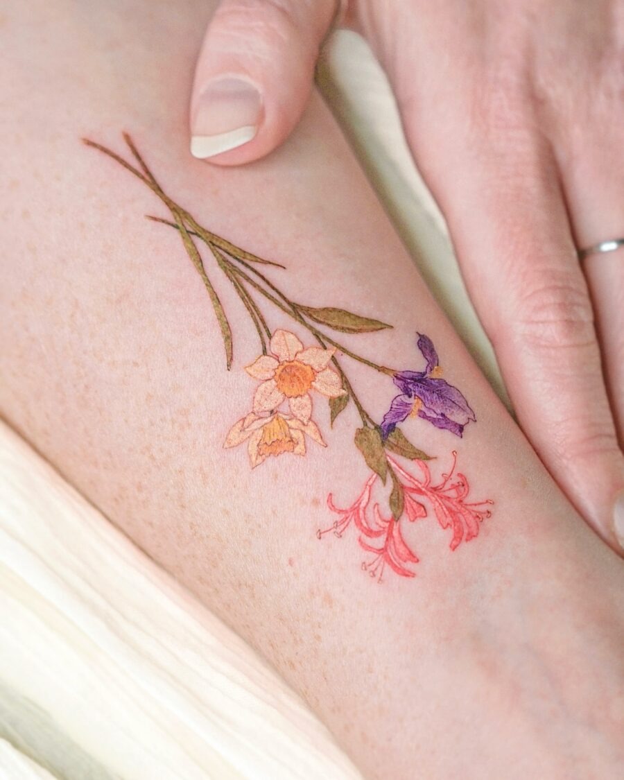 This stunning birth flower tattoo showcases a mix of delicate flowers, each beautifully detailed.