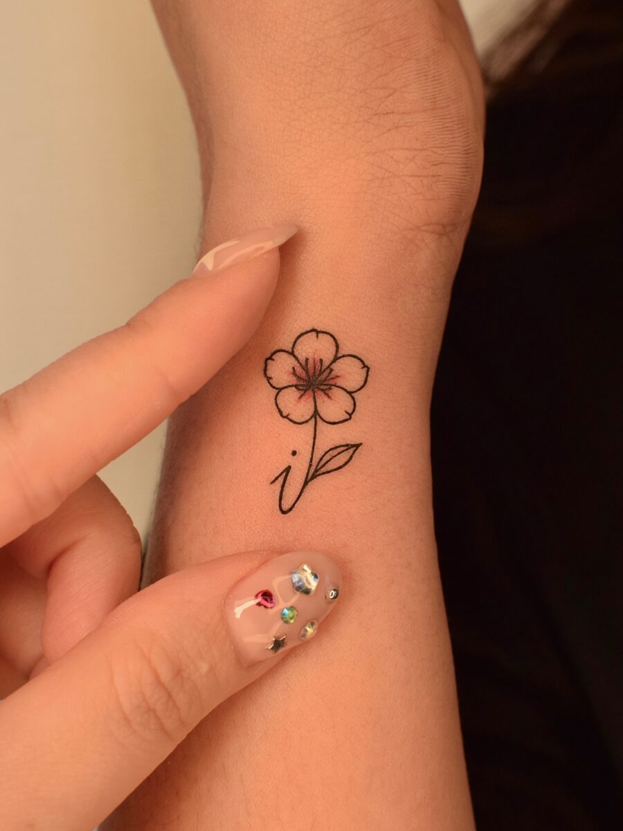 This tattoo showcases a minimalist flower design with fine black lines.
