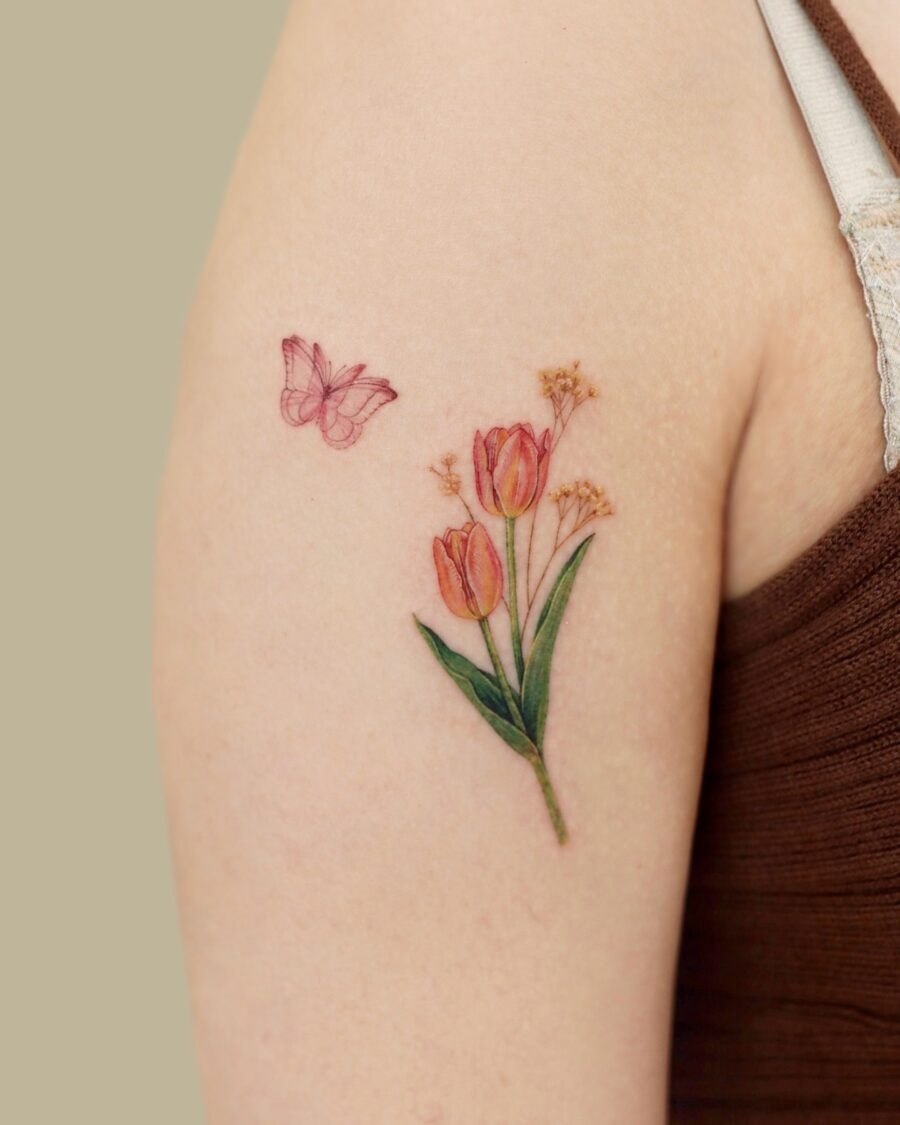 This tattoo features a beautiful bouquet of tulips complemented by a softly drawn butterfly.