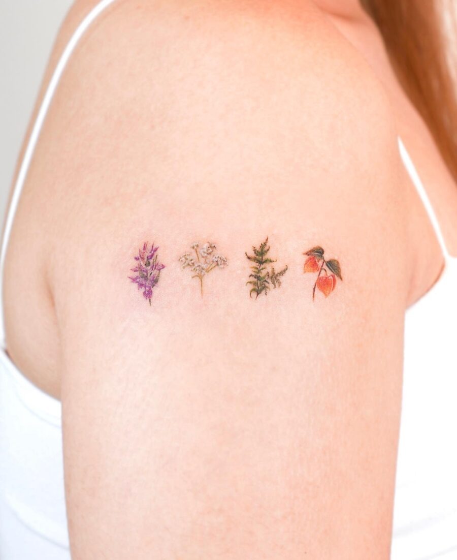 This image showcases a series of delicate birth flower tattoos arranged beautifully on the shoulder.