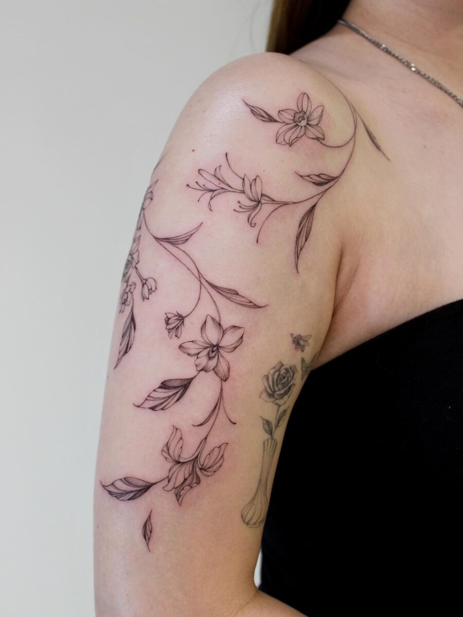 This stunning tattoo features delicate floral designs that beautifully wrap around the arm.