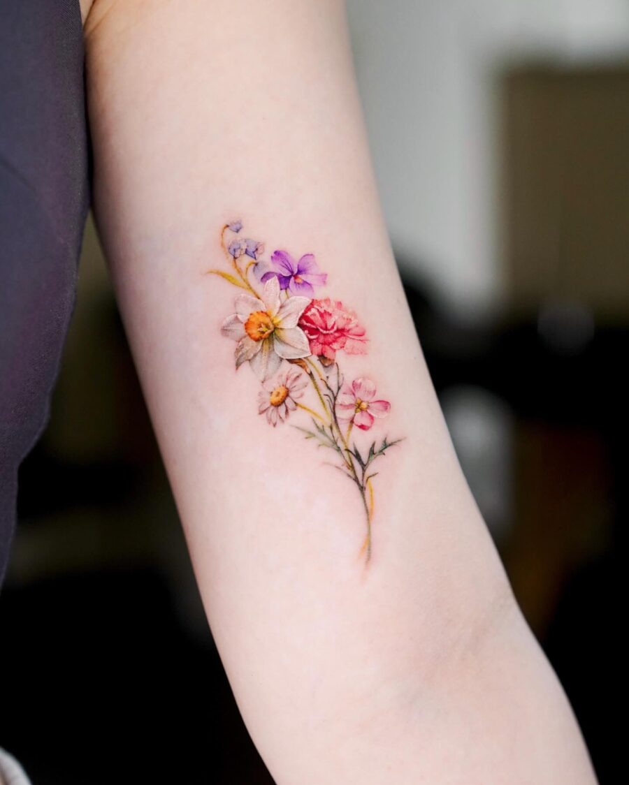 This tattoo features a beautiful arrangement of colorful flowers, representing various birth months.