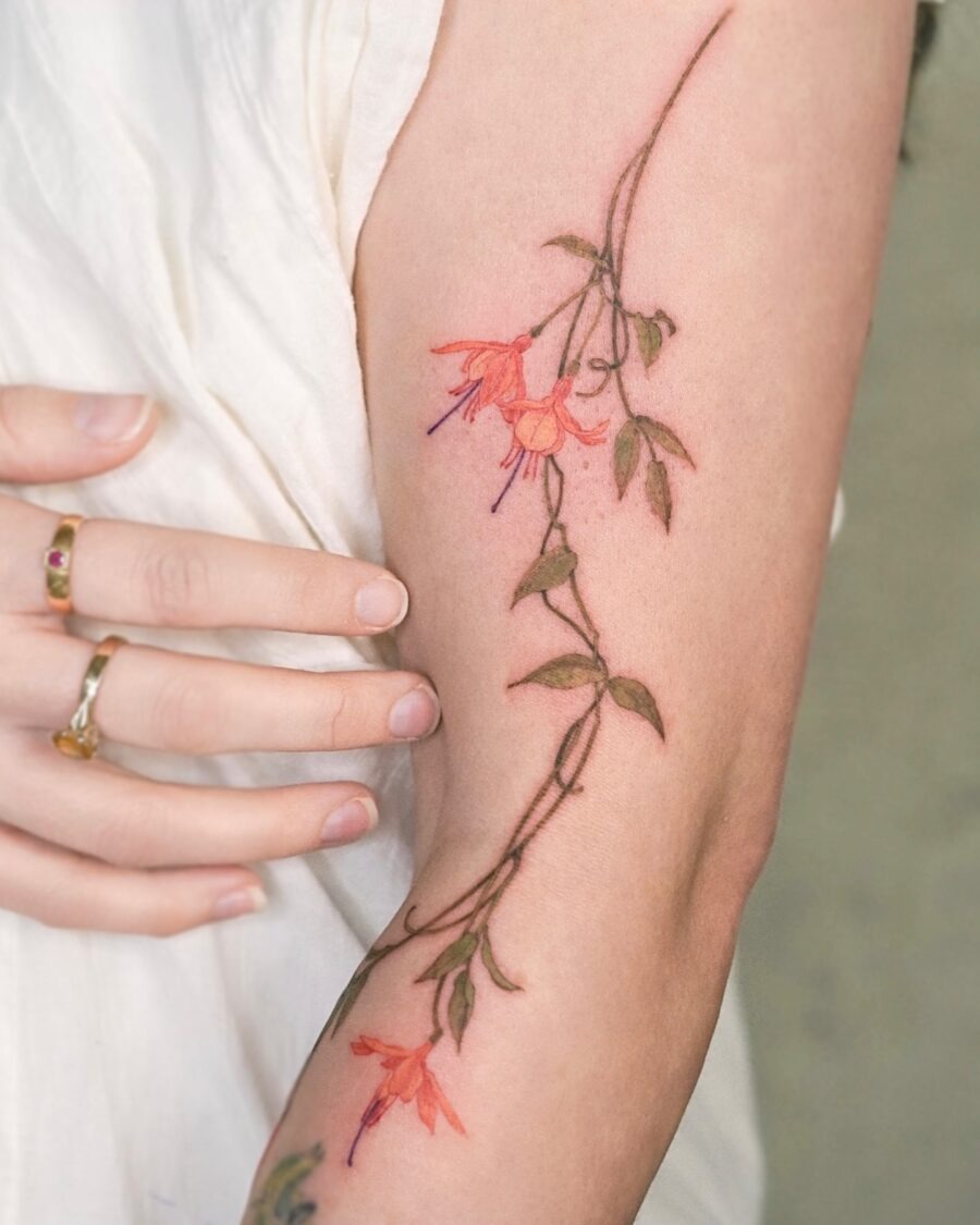 This tattoo beautifully showcases fuchsia flowers entwined with delicate foliage.