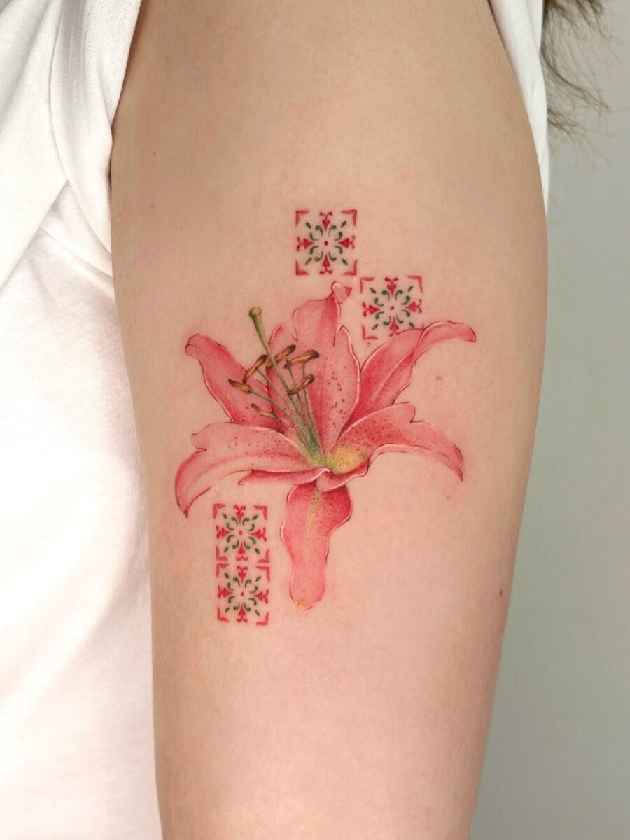 This stunning tattoo features a pink lily, symbolizing purity and passion.