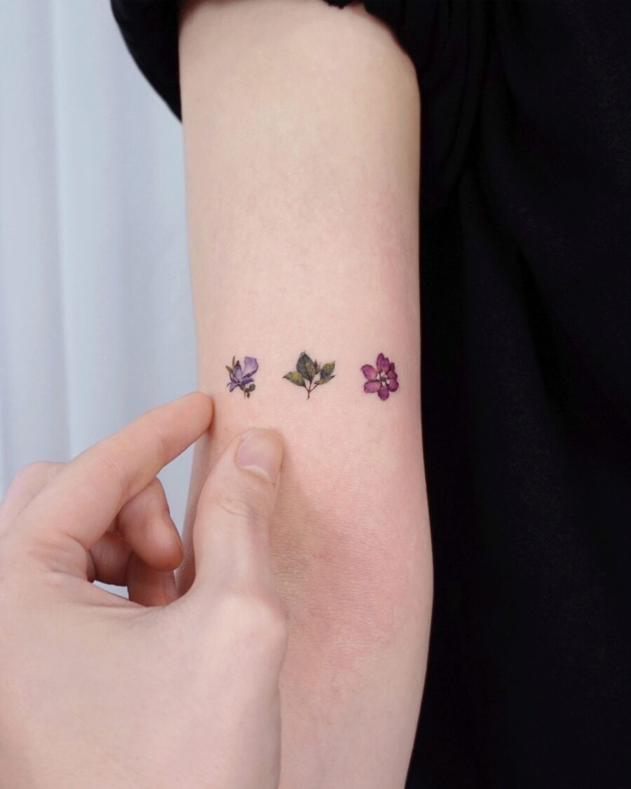 This image features delicate birth flower tattoos in shades of purple.